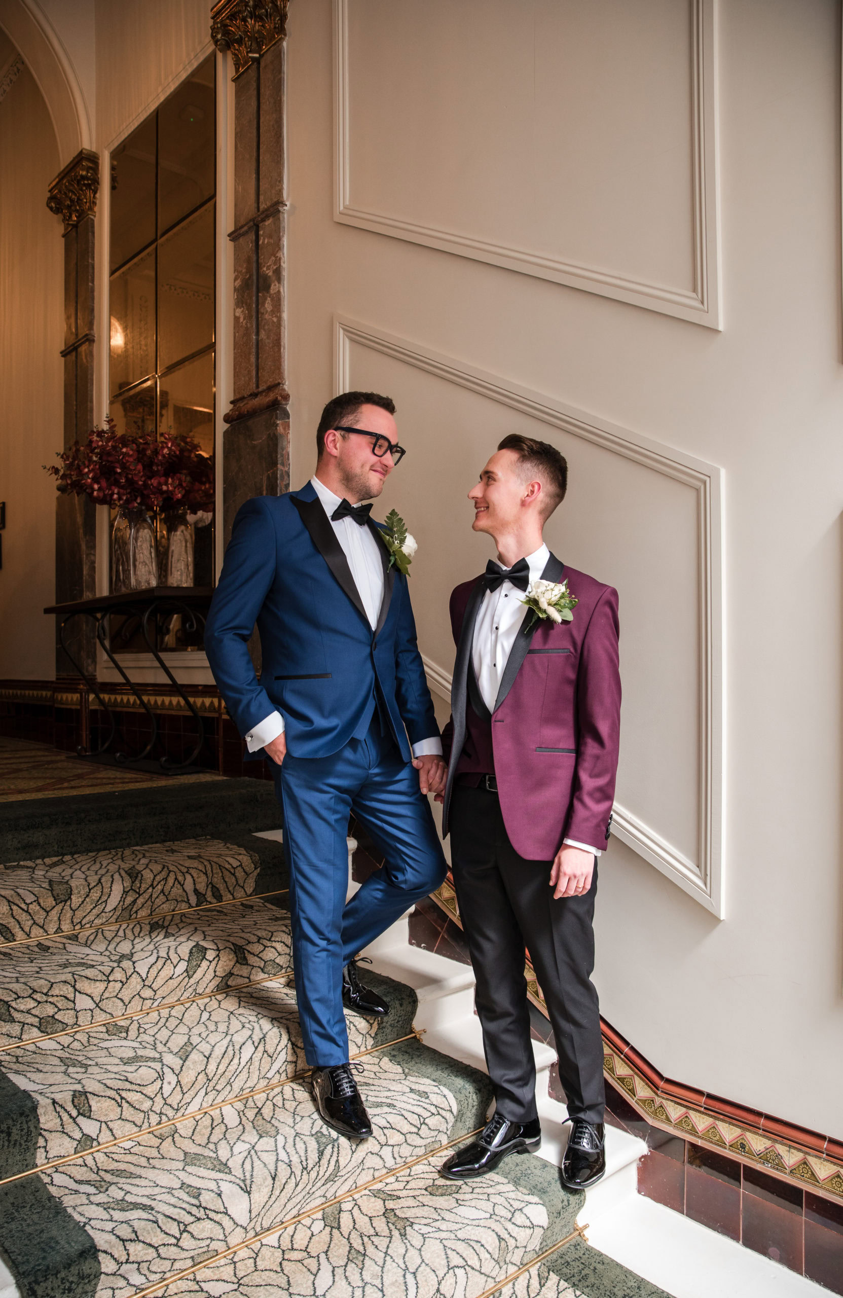 A couple hold hands on a staircase at their stylish city wedding photographed by a Birmingham wedding photographer