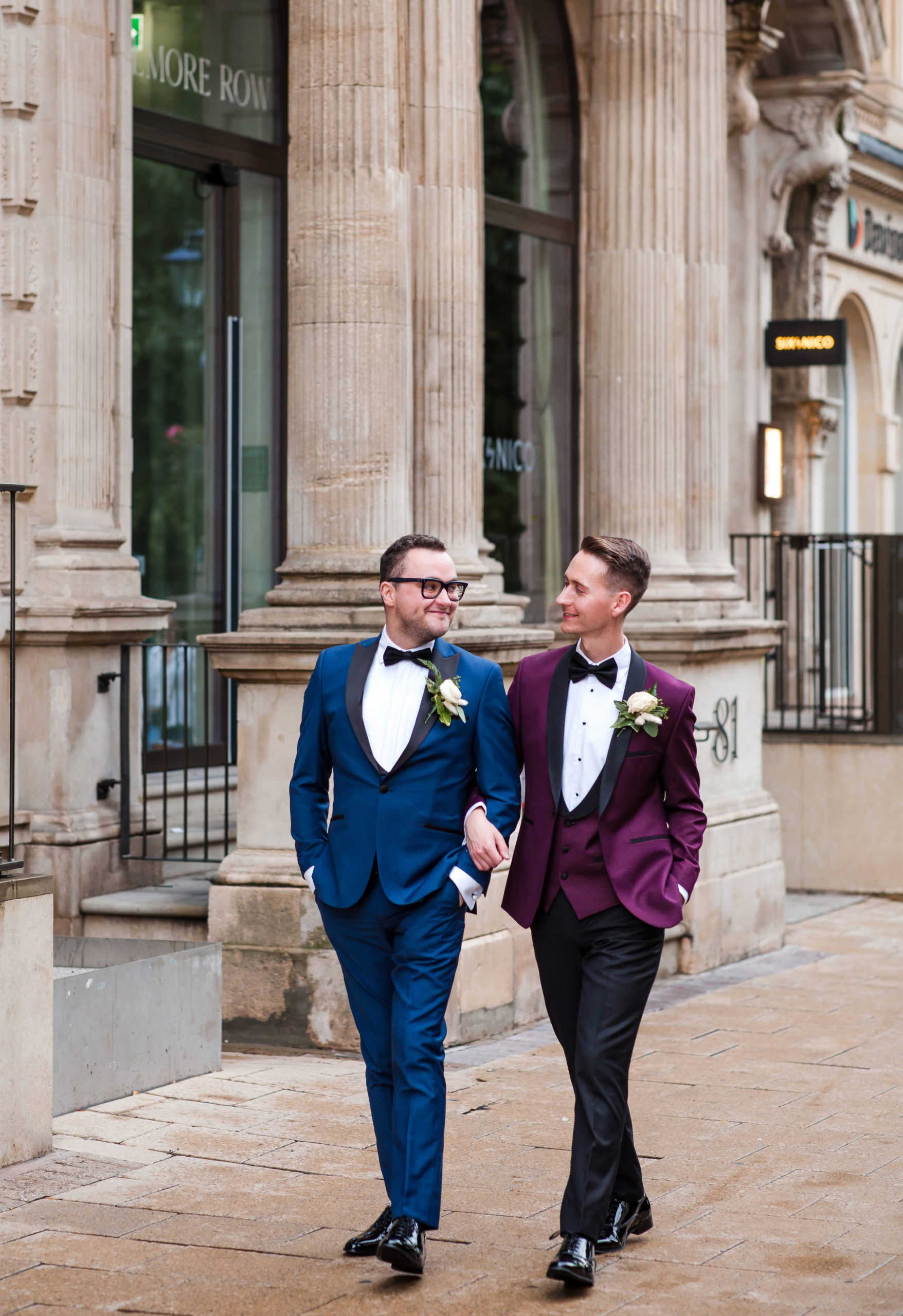 Happy Grooms arm in arm in Birmingham city centre, captured on their gay wedding day