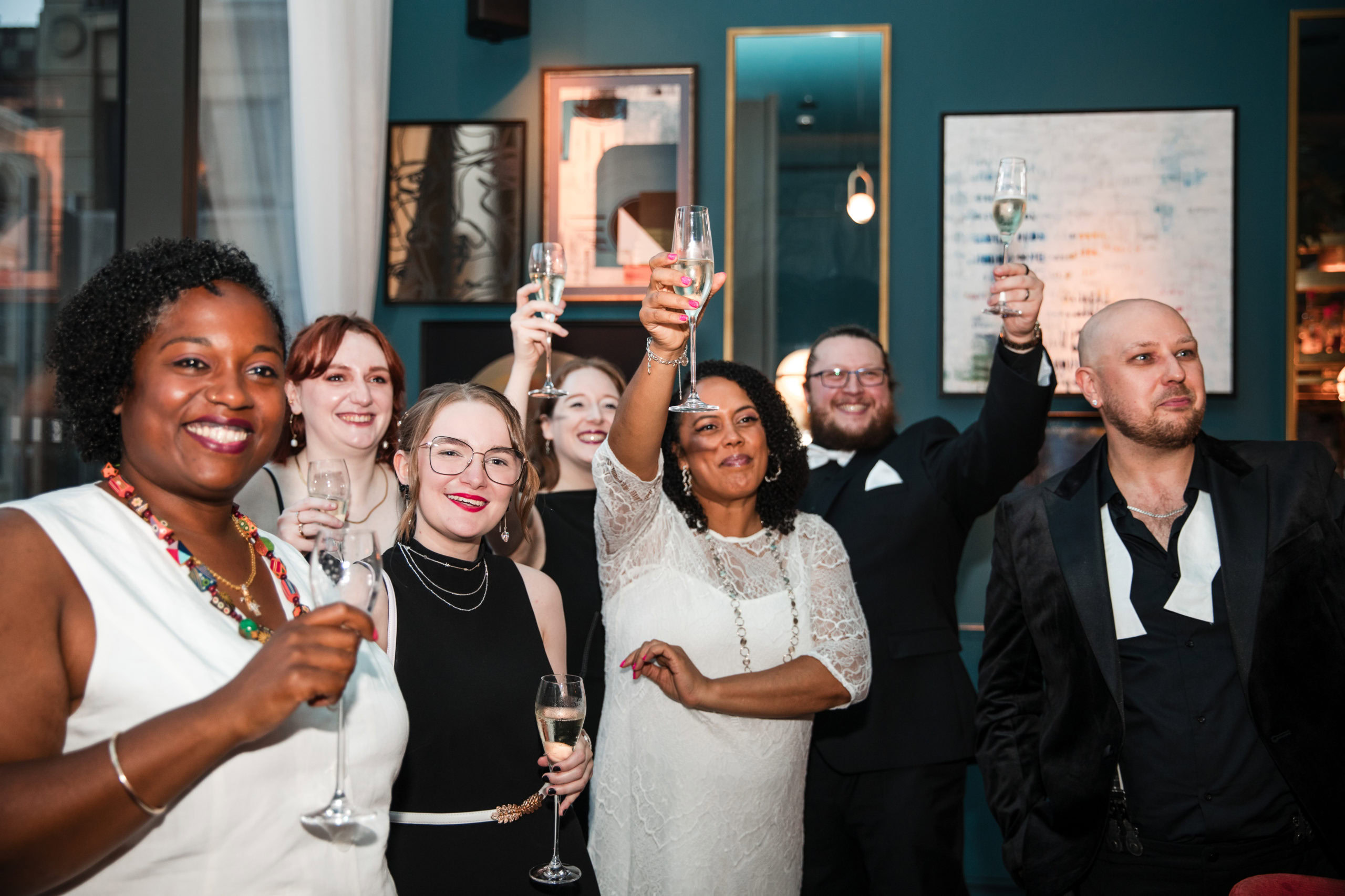 Candid photography of wedding guests raising a toast to welcome the newly married couple after a gay wedding in Birmingham