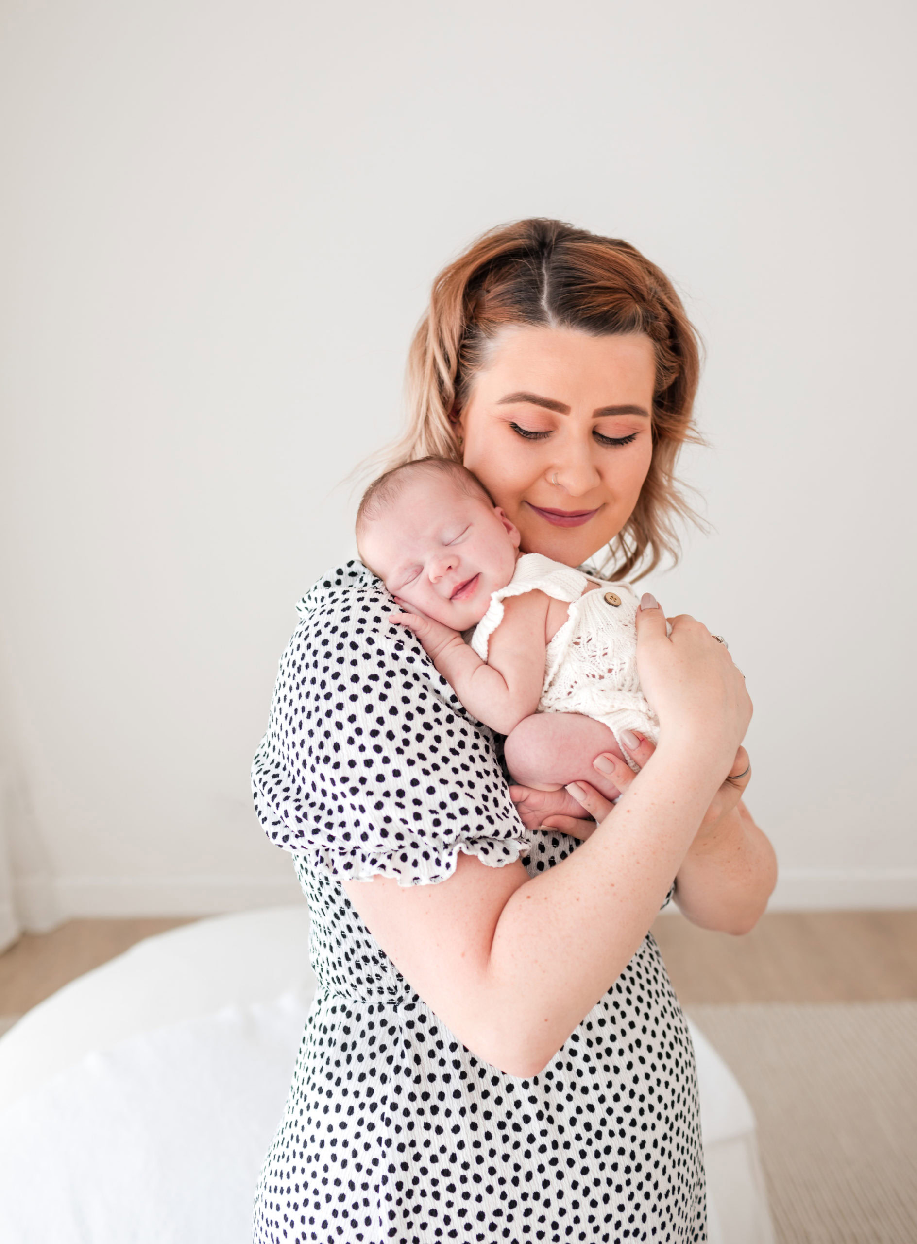 Mother cuddling her newborn baby during a natural light newborn photography session in Birmingham
