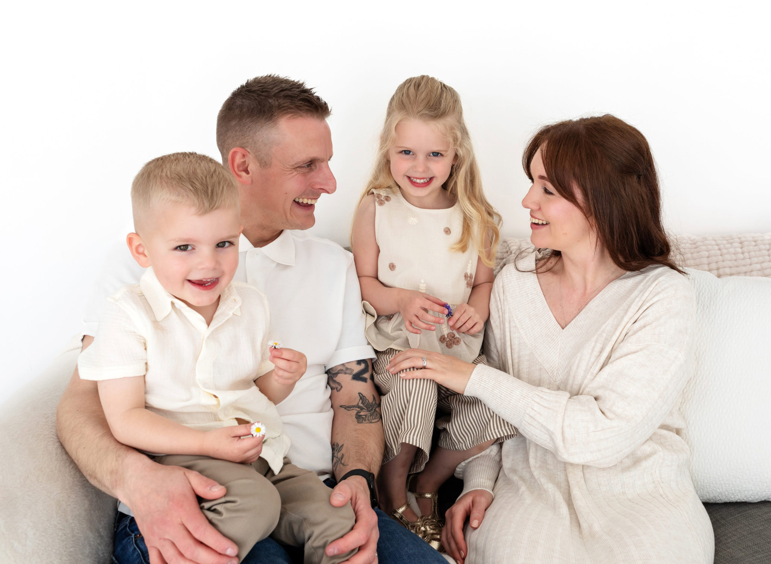 Natural photo of a family with two young children, laughing during a photoshoot in a Sutton Coldfield Studio