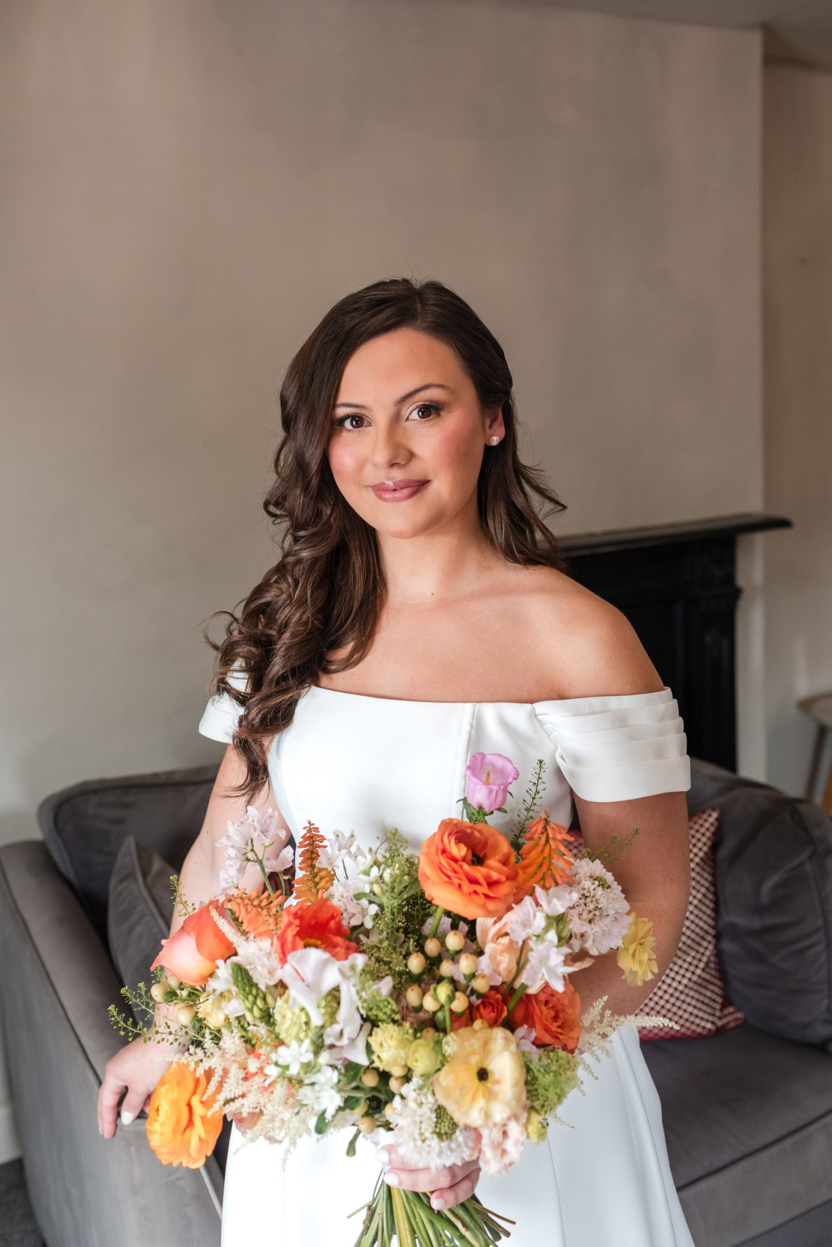 Portrait of a Bride with an off the shoulder wedding dress holding a bright colourful bouquet taken by Lichfield photographer Jo Hastings
