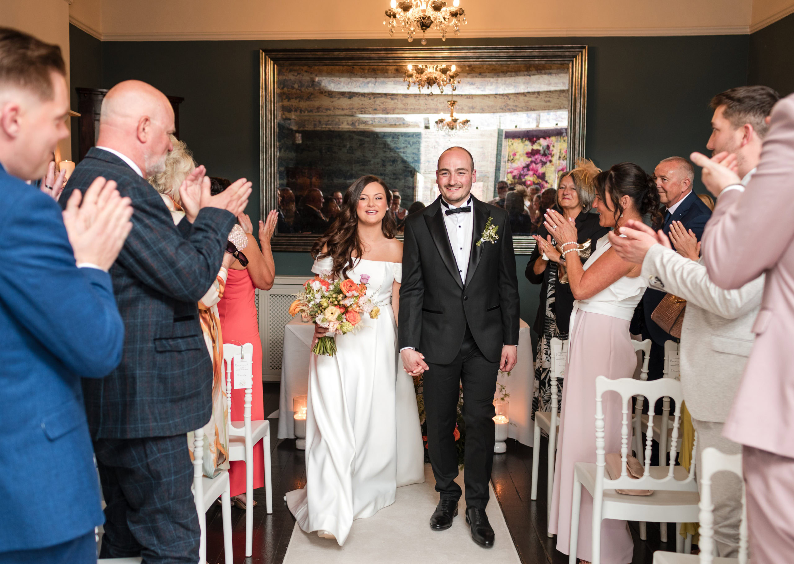 Newly married couple walk down the aisle after getting married at St Johns House Lichfield