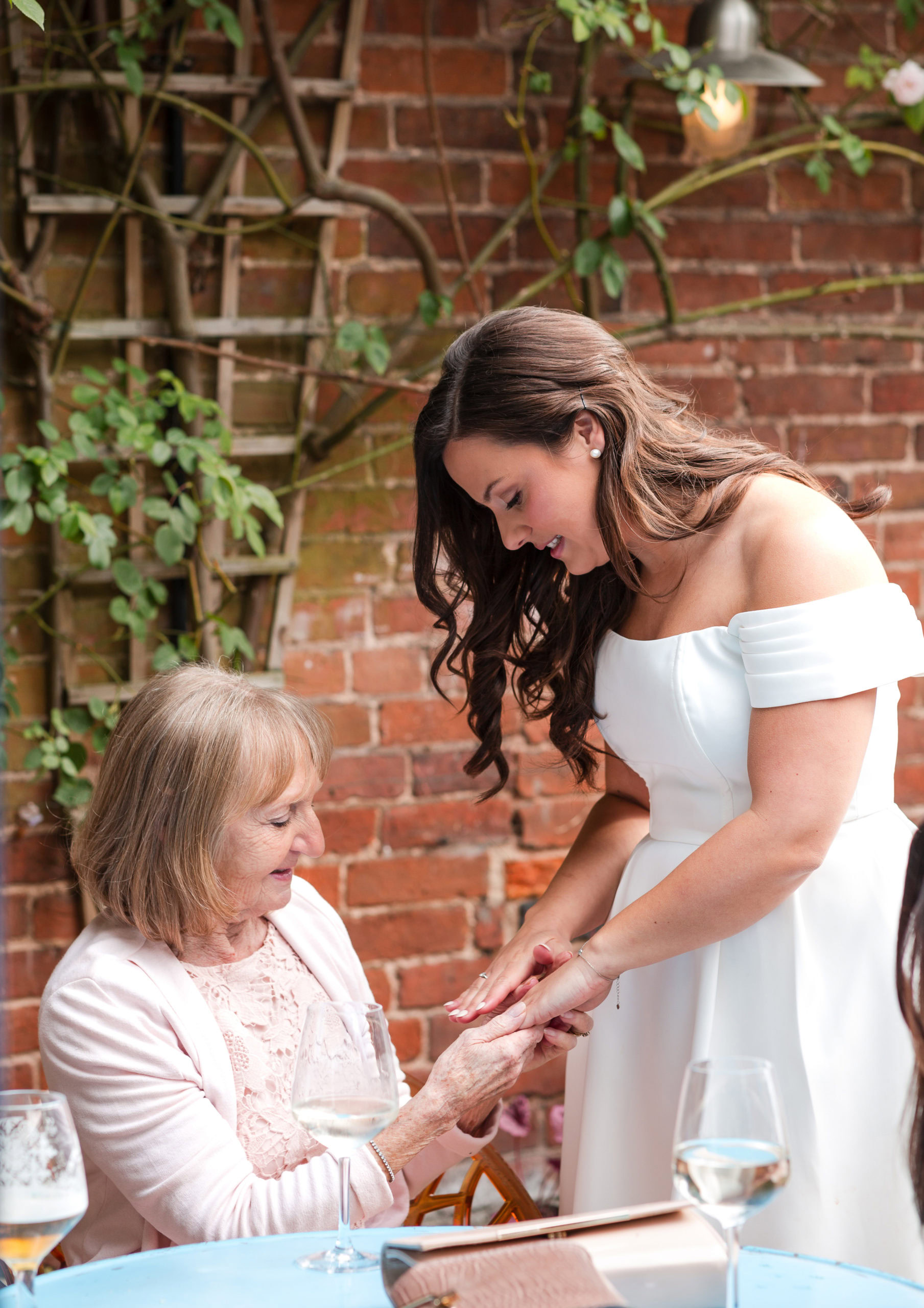Candid photo of a Bride showing her wedding ring to her Grandma
