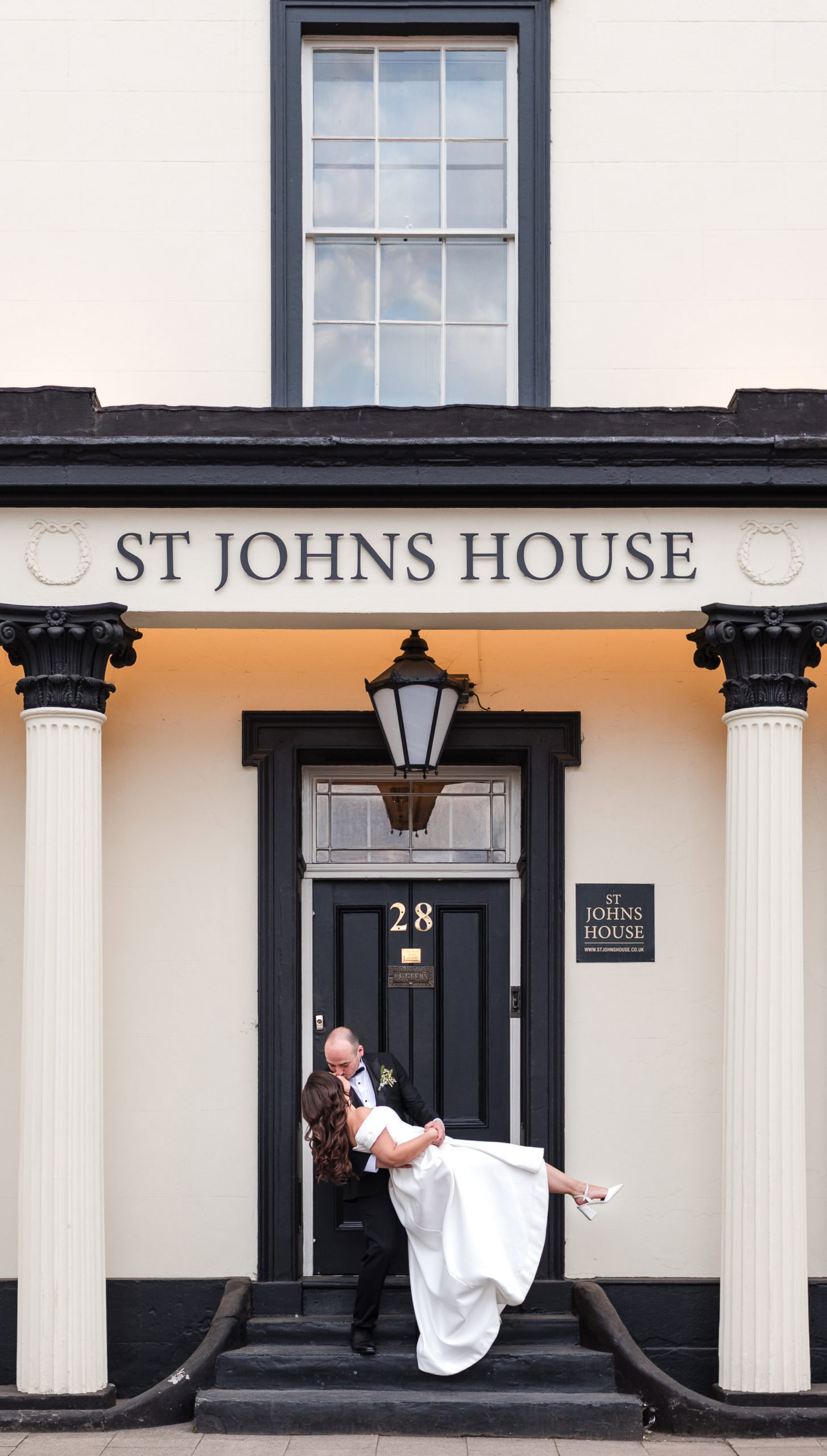 Bride and Groom having a dip kiss on the steps of St John’s House in Lichfield during their wedding day, captured as part of elegant wedding photography at this historic venue